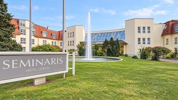 Un hotel chiamato 'Seminaris Hotel Leipzig' con una fontana nel cortile interno e un edificio moderno caratterizzato da ampie finestre.