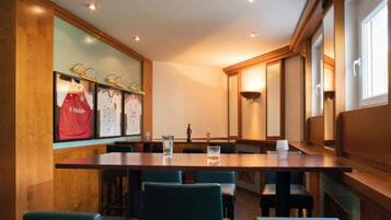 A conference room with a long table, chairs, and framed sports jerseys on the wall.