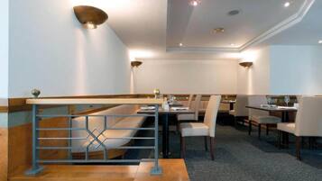 Ein Restaurant mit hoher Decke, eingelassener Beleuchtung und modernem Design.