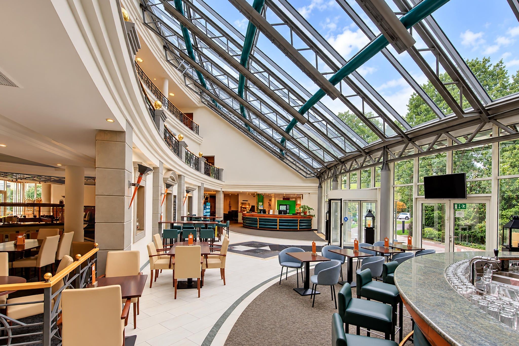 A spacious indoor area with a high ceiling, a central bar area, and multiple seating arrangements.