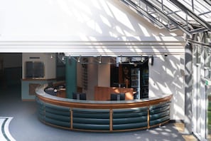 Ein modernes Interieur mit einer gebogenen Sitzecke, einem Empfangstresen und einer Glastrennwand.