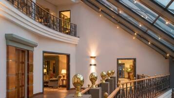 A spacious interior with a staircase, a lounge area, and a view through a glass ceiling.