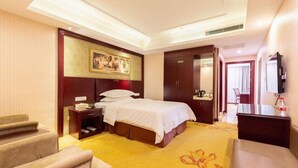 A hotel room with a bed, bedside tables, a desk, a chair, a television, and a wardrobe. - Vienna International Hotel Shanghai Jiaotong Unive (Shanghai)