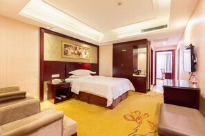 A hotel room with a bed, bedside tables, a desk, a chair, a television, and a wardrobe. - Vienna International Hotel Shanghai Jiaotong Unive (Shanghai)