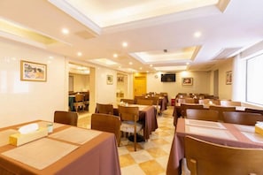 A conference room with tables and chairs, a television screen, and framed pictures on the walls. - Vienna International Hotel Shanghai Jiaotong Unive (Shanghai)