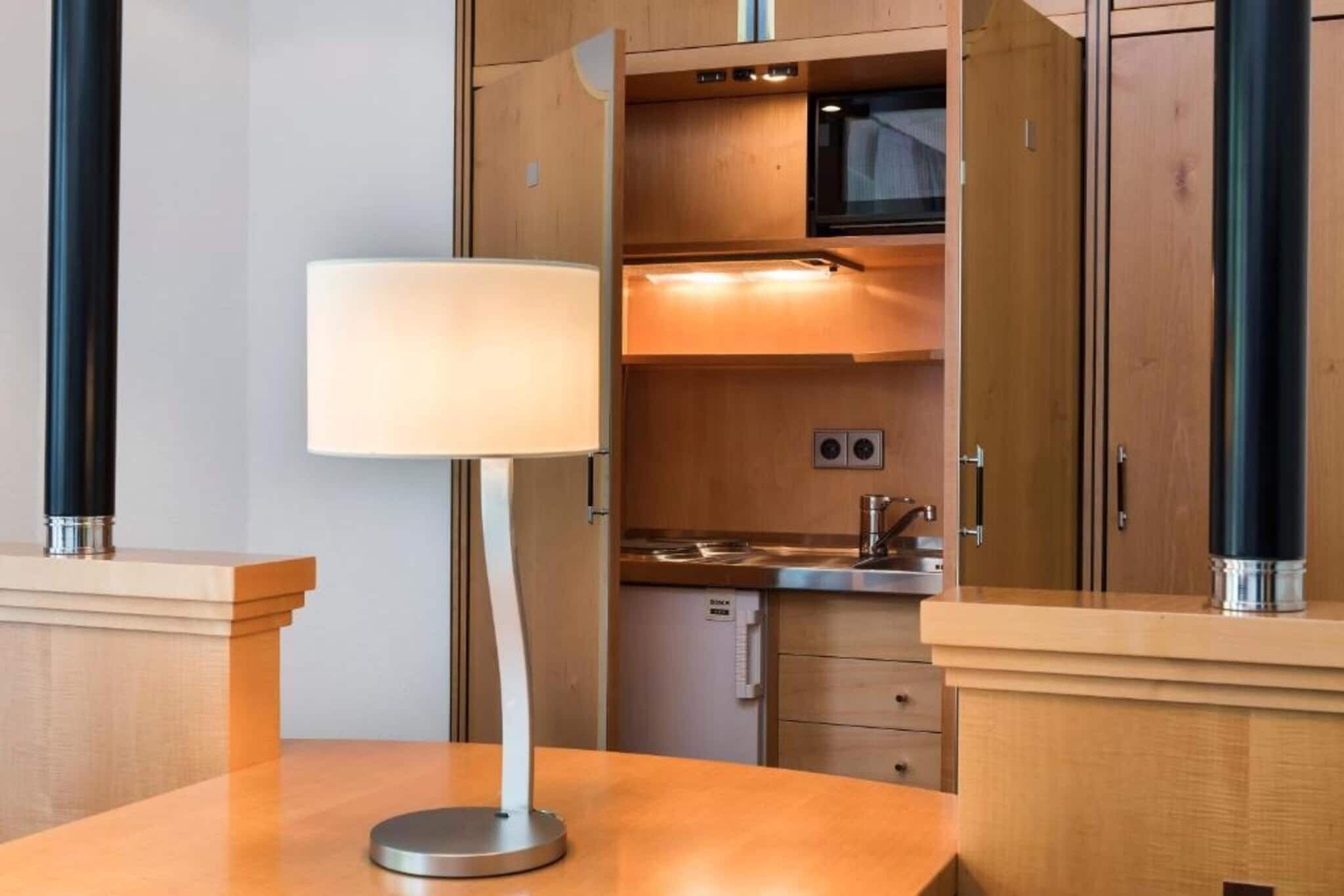 Een moderne keuken met houten kastjes, een roestvrijstalen spoelbak en een inbouwmagnetron.
