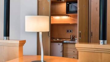 Een moderne keuken met houten kastjes, een roestvrijstalen spoelbak en een inbouwmagnetron.