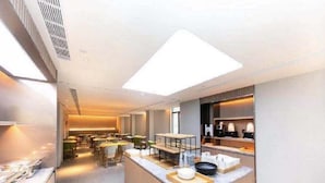 Una cocina moderna con una isla central, electrodomésticos integrados y una lámpara sobre la encimera.