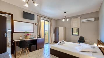 Una habitación de hotel con cama, escritorio, silla y televisión.