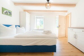 A bedroom with a bed, a window, and a door leading to another room. - Holiday apartment 2 "Hooge" (ID 471) (Tating)