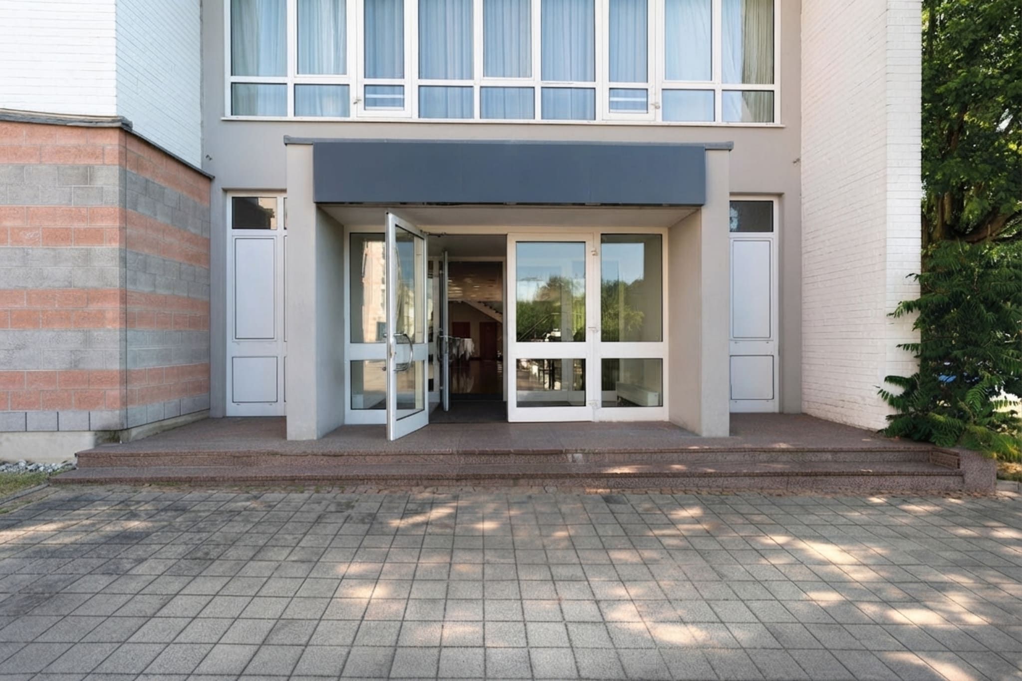 Un moderno edificio de dos pisos con entrada de vidrio y fachada de ladrillo.