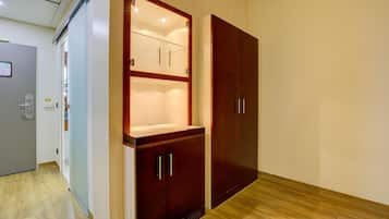A room with a wooden wardrobe, a glass cabinet, and a door with a handle.