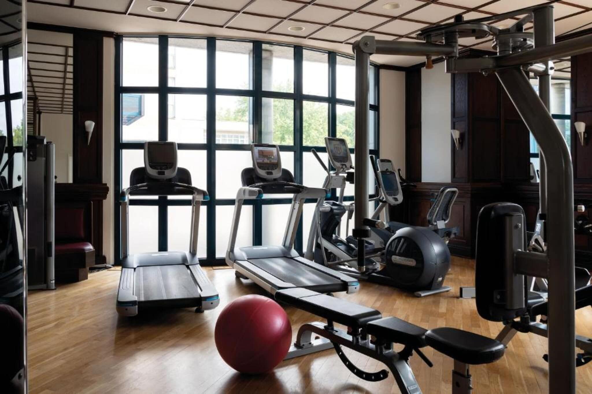 Ein Fitnessstudio mit Laufbändern, Crosstrainern und Krafttrainingsgeräten.
