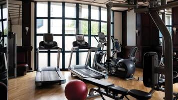 Ein Fitnessstudio mit Laufbändern, Crosstrainern und Krafttrainingsgeräten.