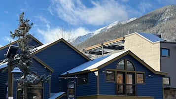 A hotel with a blue facade, large windows, and a sign indicating it is a hotel.
