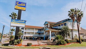 A hotel with a sign indicating it is a Scottish Inn & Suites. - Passport Inn (Kemah)