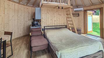 Un intérieur en bois comprenant un lit, une chaise, un bureau et une échelle.