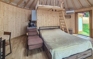 Un intérieur en bois comprenant un lit, une chaise, un bureau et une échelle.