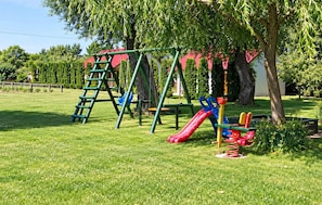 A playground with a slide, swings, and a climbing structure. - 2 bedroom beautiful home in Przewloka (Przewloka)