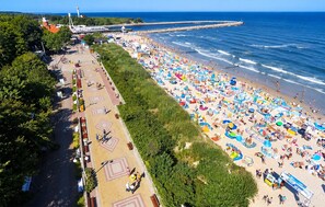A beach with a promenade lined with trees and a pier extending into the sea. - 2 bedroom beautiful home in Przewloka (Przewloka)