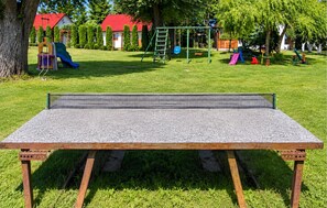A ping pong table set up outdoors with a playground in the background. - 2 bedroom beautiful home in Przewloka (Przewloka)