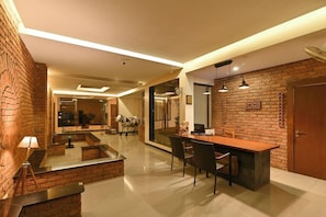Una cocina moderna con pared de ladrillo, un comedor con una mesa larga y una isla de cocina.