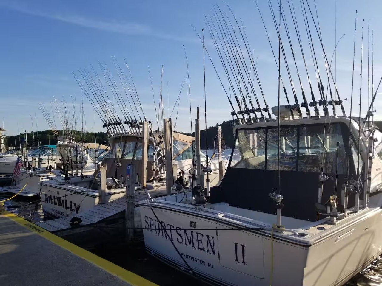 A marina with multiple boats docked, including one named 'SPORTSMEN II'.