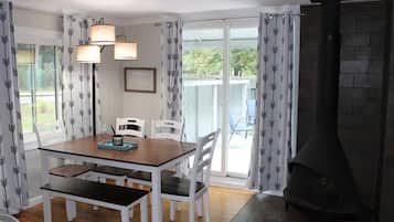 A dining area with a table, chairs, and a fireplace.