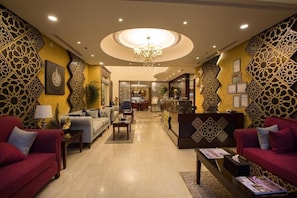 A hotel lobby with a reception desk, sofas, and a chandelier. - Sun Park Hotel Apartments (Jeddah)