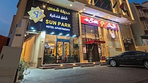 Ett hotell med en tydlig skylt som visar namnet ”Sun Park Hotel Apartments” och en väl synlig entré.