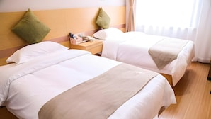 Two beds with white linens and a beige throw blanket, a wooden nightstand with a phone and a lamp, and a window with curtains. - Greentree Inn Nanjing Zhongshan Mausoleum Scenic Area Zhongling Street Subway Station (Nanjing)