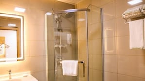 A bathroom with a glass-enclosed shower, a sink, and a towel rack. - Greentree Inn Nanjing Zhongshan Mausoleum Scenic Area Zhongling Street Subway Station (Nanjing)