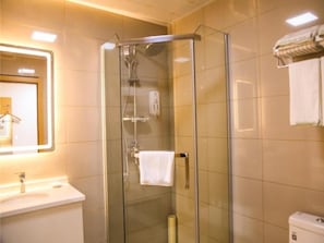 Ein Badezimmer mit einer gläsernen Duschkabine, einem Waschbecken und einem Handtuchhalter.