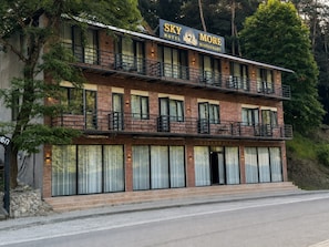 A two-story building with a sign for 'Sky Hotel More Restaurant' on the upper level.