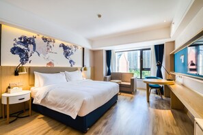 A modern hotel room with a large bed, a desk, a chair, and a world map on the wall. - Kyriad Marvelous Hotel Haerbin West High-speed Railway Station Wanda (Harbin)