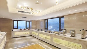 A modern kitchen with a marble countertop, stainless steel appliances, and large windows. - Kyriad Marvelous Hotel Haerbin West High-speed Railway Station Wanda (Harbin)