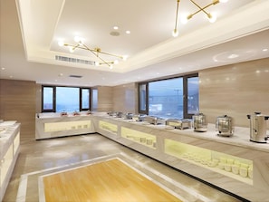 A modern kitchen with a marble countertop, stainless steel appliances, and large windows. - Kyriad Marvelous Hotel Haerbin West High-speed Railway Station Wanda (Harbin)