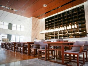 Eine geräumige Lobby mit einer langen Rezeption, mehreren Sitzbereichen und einem großen Fenster mit Regalen.