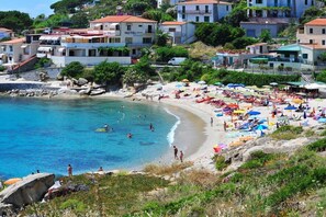 Ein Küstenhotel mit Strand, Schwimmbereich und mehreren Balkonen mit Meerblick.