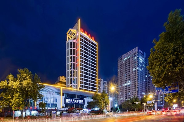 A modern hotel with a prominent vertical design, multiple floors, and illuminated signage. - Rezen Hotel (Linyi)