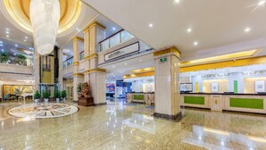 A multi-level lobby with a central atrium, marble flooring, and a grand chandelier. - Rezen Hotel (Linyi)