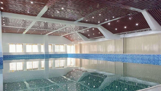 Ein Innenpool mit freier Sicht auf Decke und Wände, sowie ein gefliester Boden.