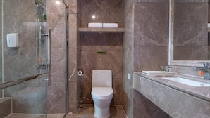 A modern bathroom with a glass-enclosed shower, a toilet, and a vanity with a mirror. - Venus International Hotel Guangzhou Jiaokou Metro Station (Guangzhou)