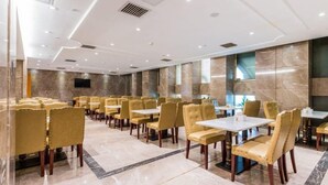 A hotel dining area with rows of tables and chairs, marble flooring, and a modern ceiling design. - Venus International Hotel Guangzhou Jiaokou Metro Station (Guangzhou)