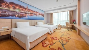 A hotel room with two beds, a desk, a chair, a TV, and a large window. - Venus International Hotel Guangzhou Jiaokou Metro Station (Guangzhou)