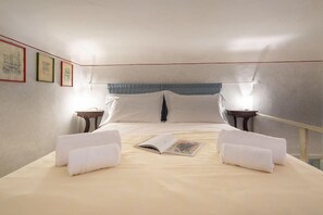 Una habitación de hotel con una cama, dos mesitas de noche y un ventanal.
