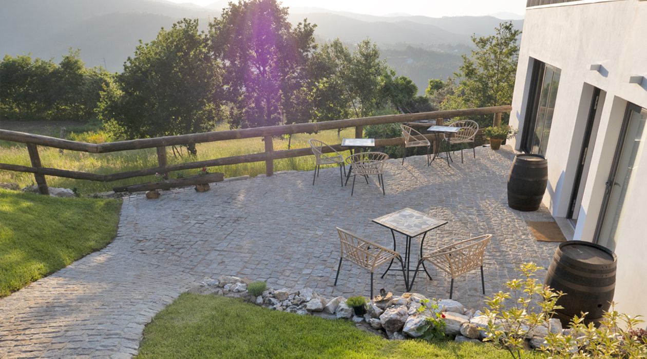 A patio with outdoor furniture, a wooden fence, and a view of the landscape.