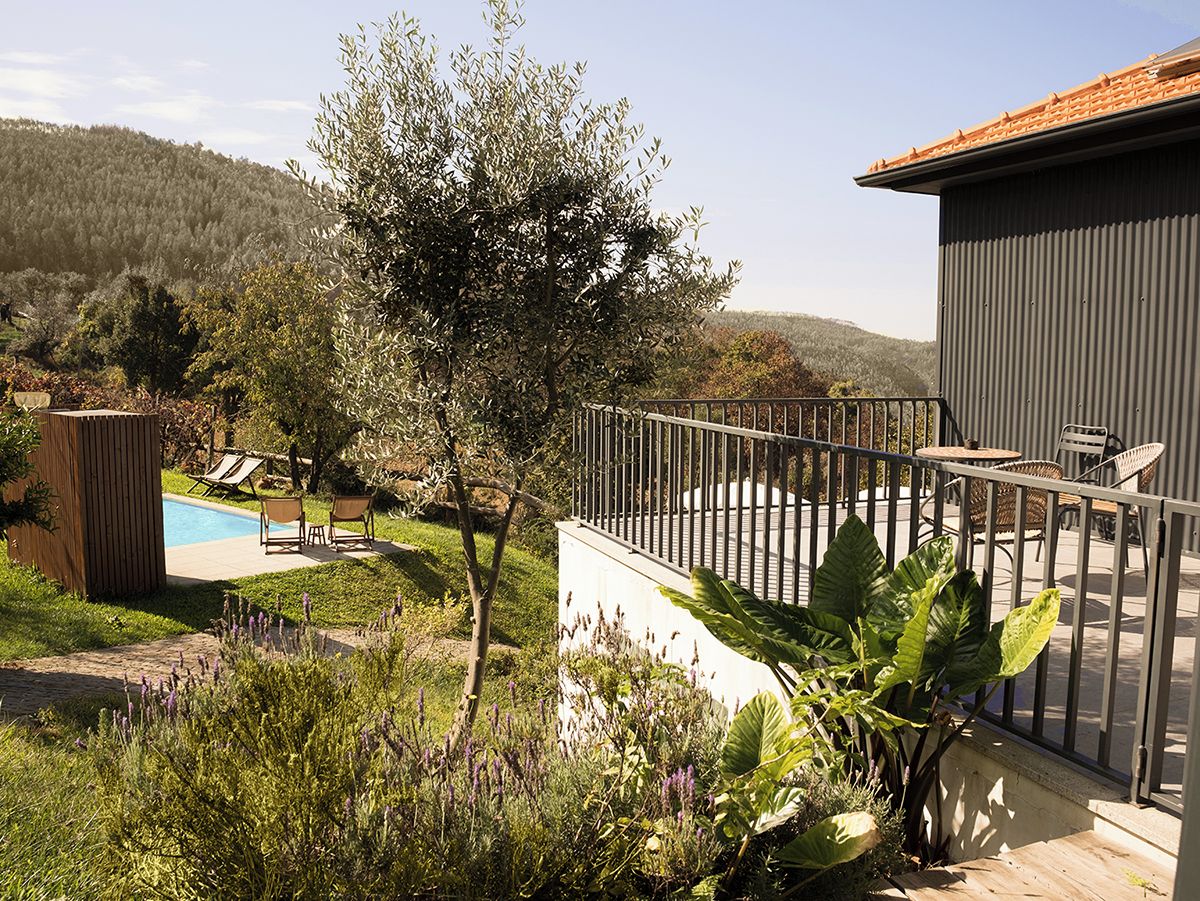Ein Wohnbereich im Freien mit Swimmingpool, Liegestühlen und einer umzäunten Terrasse.