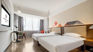 A hotel room with two beds, a desk, and a chair. - Borrman Hotel (Hezhou)