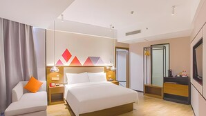 A modern hotel room with a bed, a sofa, a desk, and a mirror. - Borrman Hotel (Hezhou)